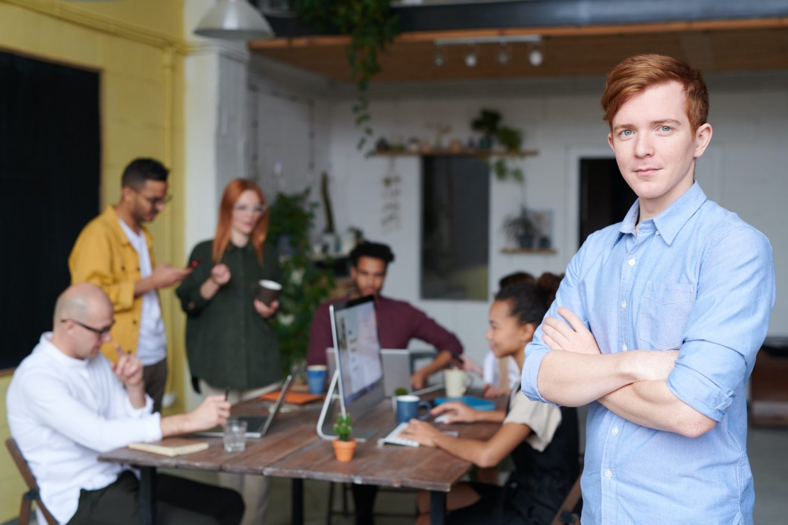 Prideful business owner in the foreground with his team behind him